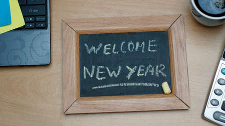 Welcome new year written on a chalkboard at the officeの写真素材