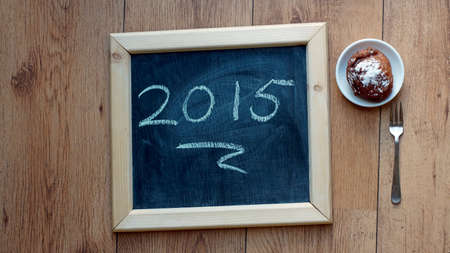 Happy 2015 written on a chalkboard next to a Dutch donutの写真素材