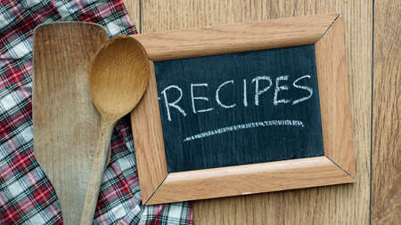 Recipes written on a chalkboard next to kitchen toolsの写真素材