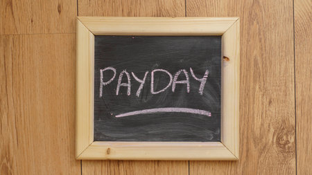 Payday written on a chalkboard at the officeの写真素材