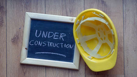 Under construction written on a chalkboard at the officeの写真素材