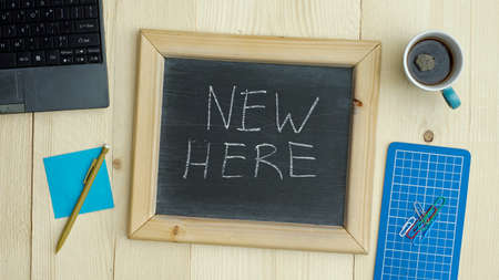 New here written on a chalkboard at the officeの写真素材