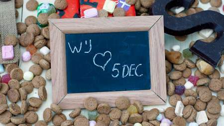 We love 5th of December in Dutch written on a chalkboard between ginger nuts and candy's for the Dutch Santa-Claus celebration of the 5th of Decemberの写真素材