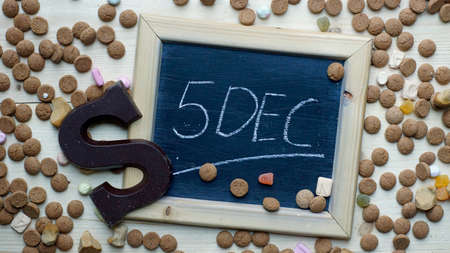 5th of December in Dutch written on a chalkboard between ginger nuts and candy's for the Dutch Santa-Claus celebration of the 5th of Decemberの写真素材