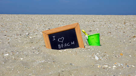 I love the beach written on a chalkboard at the beach in front of the seaの写真素材