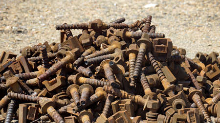 Many old parts and rusty screws on a big pile