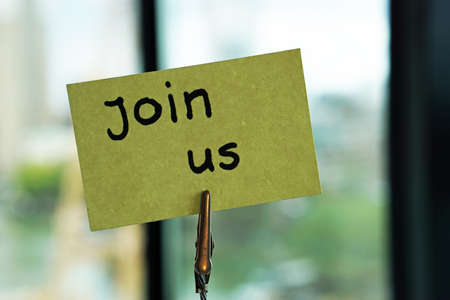 Join us written on a memo at the office in the city                            