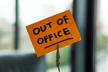 Out of office written on a memo at the office in a city                             の写真素材