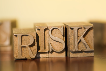 The word RISK spelled out with letterpress blocks.