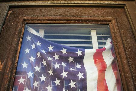 Detail of US flag hanging in an old doorway.の写真素材