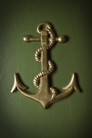 Close up of an anchor decoration on a painted wood background.の写真素材