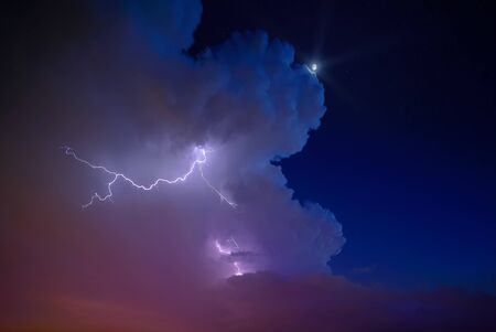 Ligtning and moon lit sky with dramatic cloudscape.の写真素材