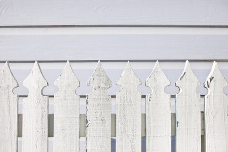 Decorative white picket fence, white siding.の写真素材