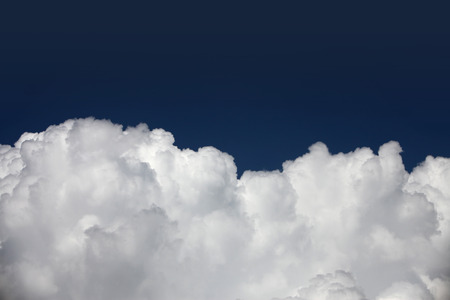 Detail of white fluffy clouds on dark sky.の写真素材