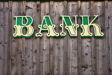 Western Style Bank sign on wooden building wall.の写真素材