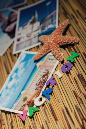 Stock photo of the word vacation along with various (original - by author) photos and star fish on a wicker surface.の写真素材