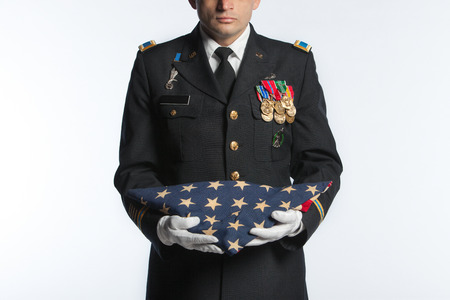 Soldier holding a folded flag.の写真素材