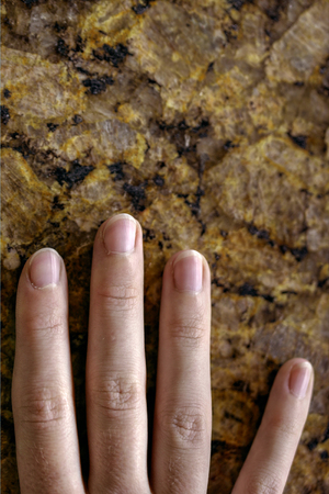 Detail of hand touching Marble counter top.の写真素材