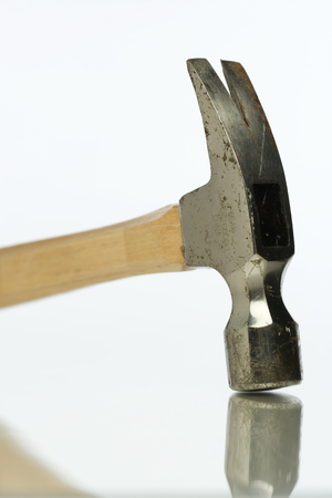 Hammer sitting on a reflective surface.の写真素材