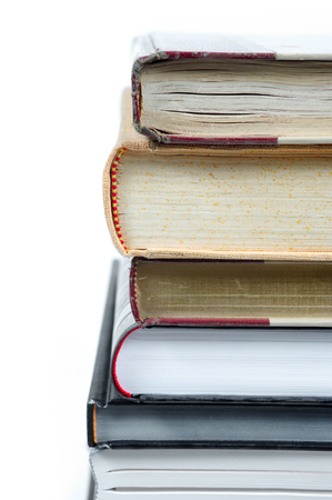 Detail of books stacked on white background の写真素材