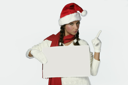 Woman wearing santa hat and holding signの写真素材