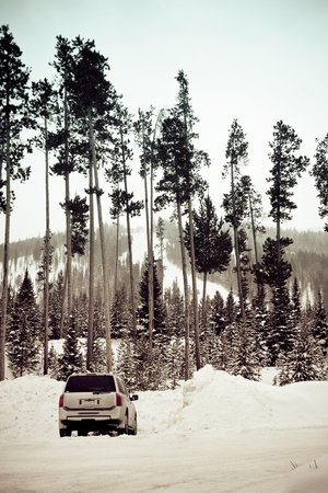 Mountain ski resort with one car in the parking lot.