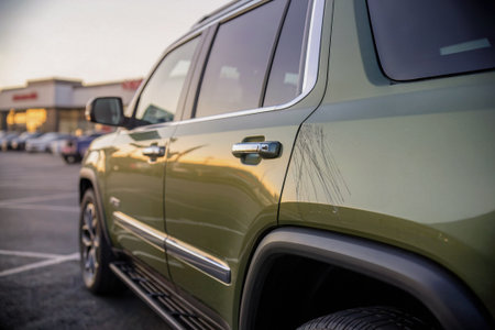 Car damage detail, scratched paint on side of SUV vehicle parked in public parking lot. keyed car detail.の素材