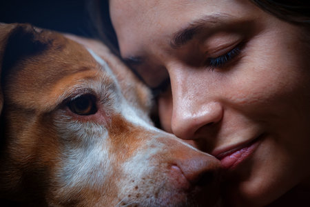 woman and her dog cheek to cheek portrait showing connection, love and compassion between a human and a pet.の素材