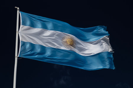 Argentina flag blowing in strong wind against dark skyの写真素材