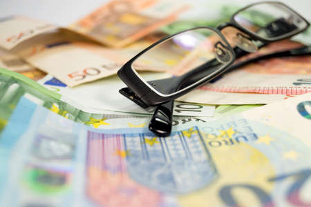 A pair of glasses and moneyの写真素材