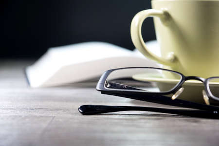 A book, glasses and a cup of coffeeの写真素材