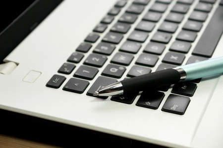 Fountain pen and a laptopの写真素材