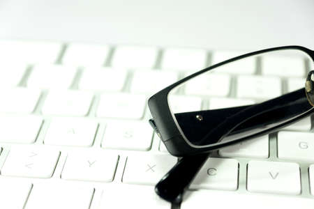 Reading glasses and a computer keyboardの写真素材