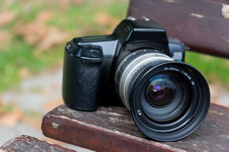 A photo camera on a park bench