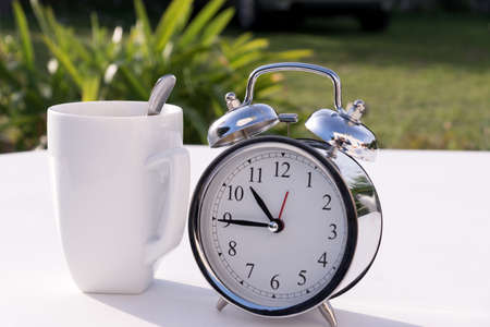 An alarm clock and a cupの写真素材
