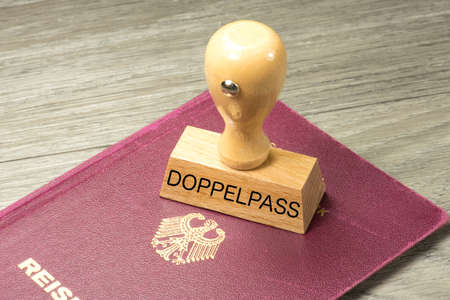 A German passport and a stamp with the imprint Doppelpassの写真素材