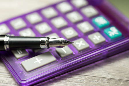 A calculator and a fountain penの写真素材