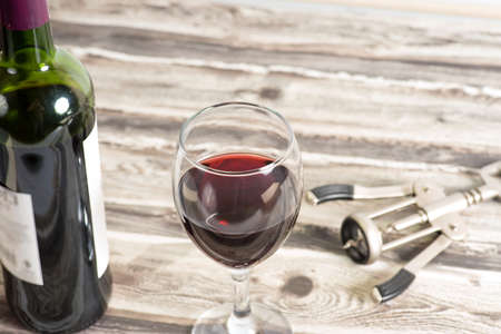 Bottle of wine a glass and a glass of wine abottle and a corkscrew