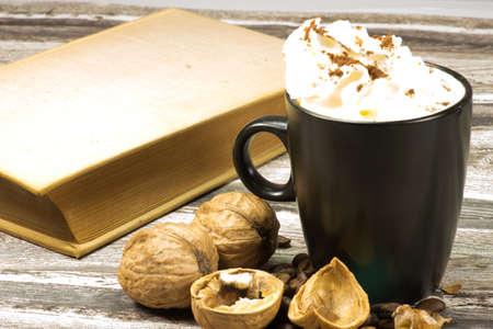 A cup of cappuccino and a bookの写真素材