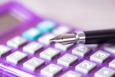 A calculator and a fountain penの写真素材