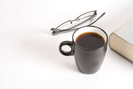 A cup of coffee, glasses and a bookの写真素材