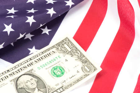 A dollar bill and the American flagの写真素材