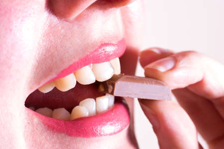 A woman is eating chocolateの写真素材
