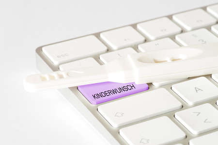 A pregnancy test and a computer keyboard with the key to children