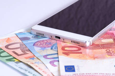 Euro banknotes and smartphoneの写真素材