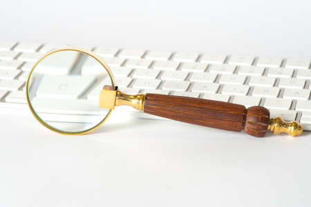 A magnifying glass and a computerの写真素材