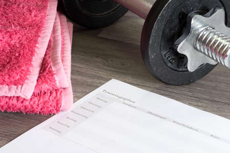 Dumbbell, towel and a training plan