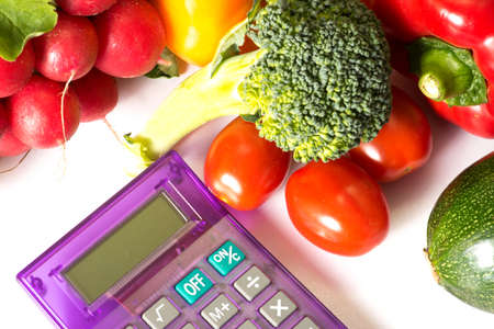 A calculator and and different vegetablesの写真素材