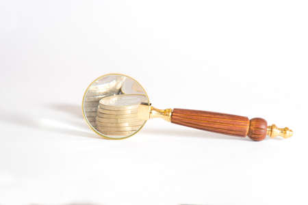 A magnifying glass and many euro coinsの写真素材
