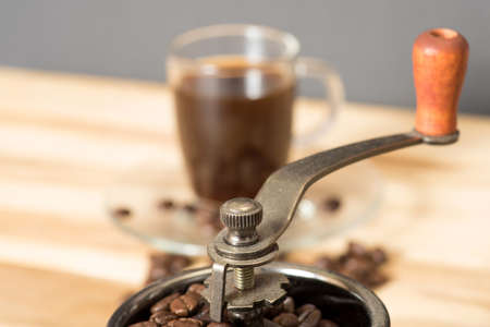 Grinder with coffee beans and a cupの写真素材